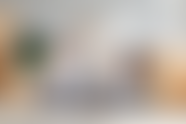 Happy family of three sitting on floor surrounded by moving boxes