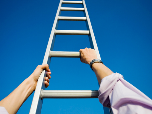 Hands on a ladder that’s extending up into a blue sky