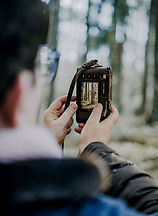 Nadine schaut im Sucher ihrer Kamera auf ein gerade fotografiertes Bild. es ist intuitiv entstanden und hat eine bedeutsame Wirkung in diesem Moment.