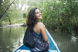 Laís sorrindo sentada na canoa