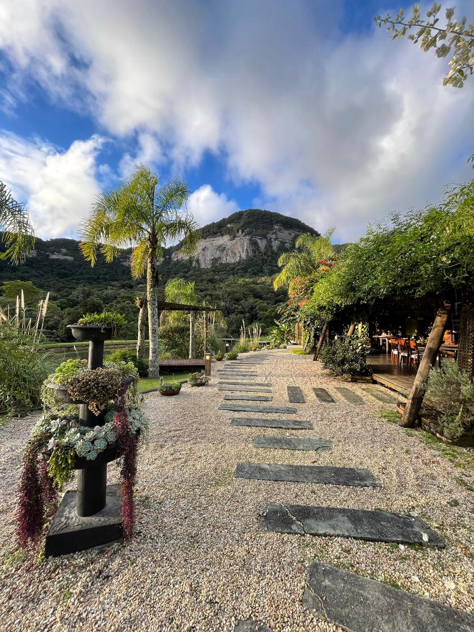 Jardins, riacho e paredão de pedra no Vale dos Ventos