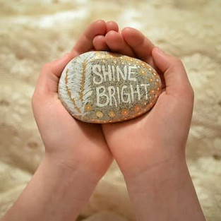 rock with the words shine bright painted on it