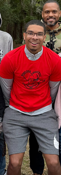 Man in red shirt smiles outdoors