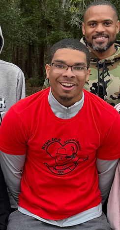 Smiling man in red shirt with logo