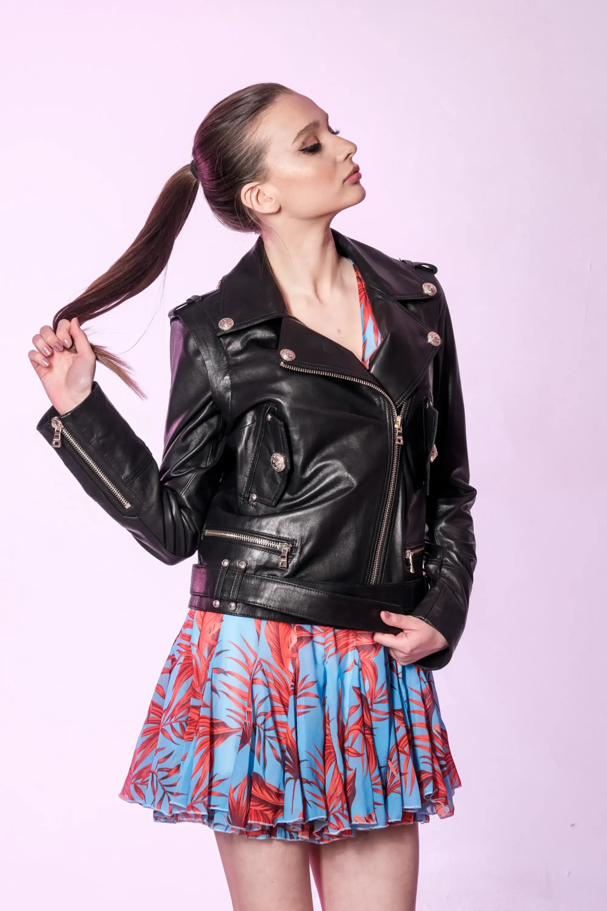 Woman wearing a black Körüklü Hakiki Deriden Ceket Yaka Deri Ceket posing on pink background Divalore.