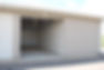 Image of medium enclosed storage unit with concrete floor and overhead, roll-up door. Fully enclosed space with concrete apron and asphalt exterior.