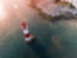 A Drone photo of a lighthouse out at sea