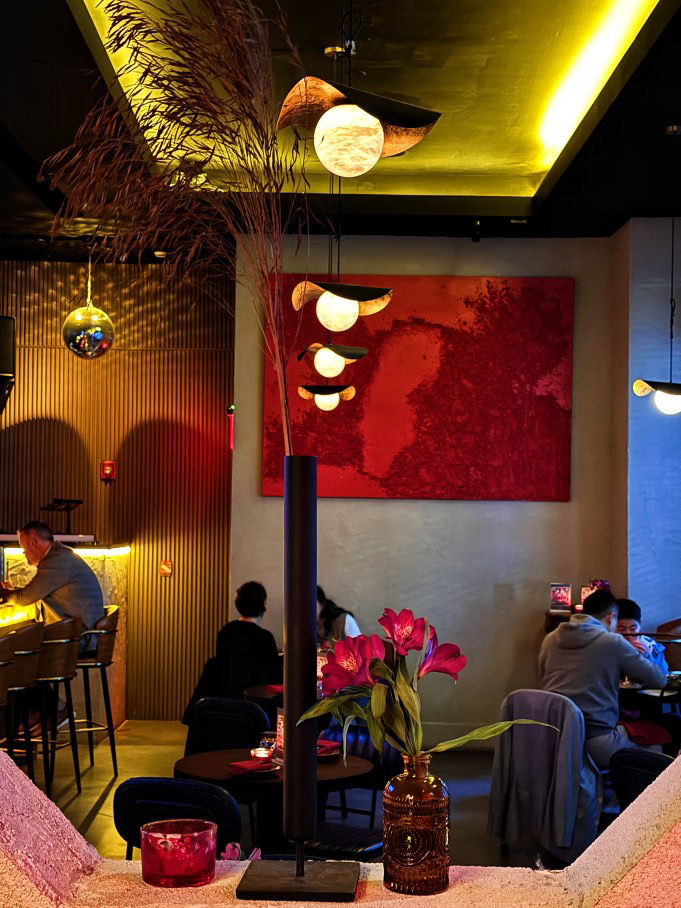 Eye-level view of a dimly lit bar interior with exposed brick walls and vintage lighting