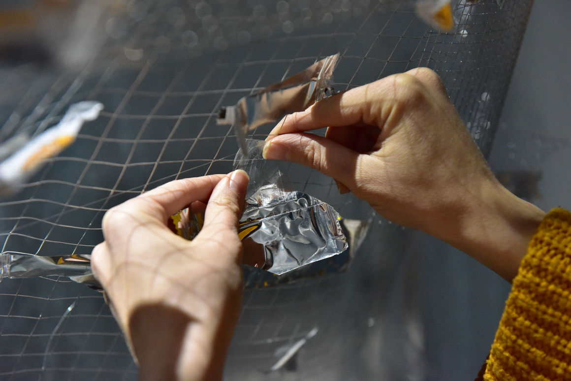 Close-up of hands putting up the aluminum wrap.