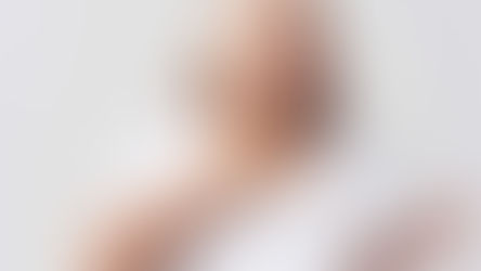 Mujer mayor con expresión de dolor, tocándose el cuello con una mano, lo que sugiere molestia o dificultad para tragar.