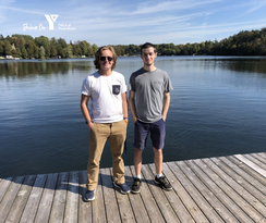 2 men standing on a dock smiling.