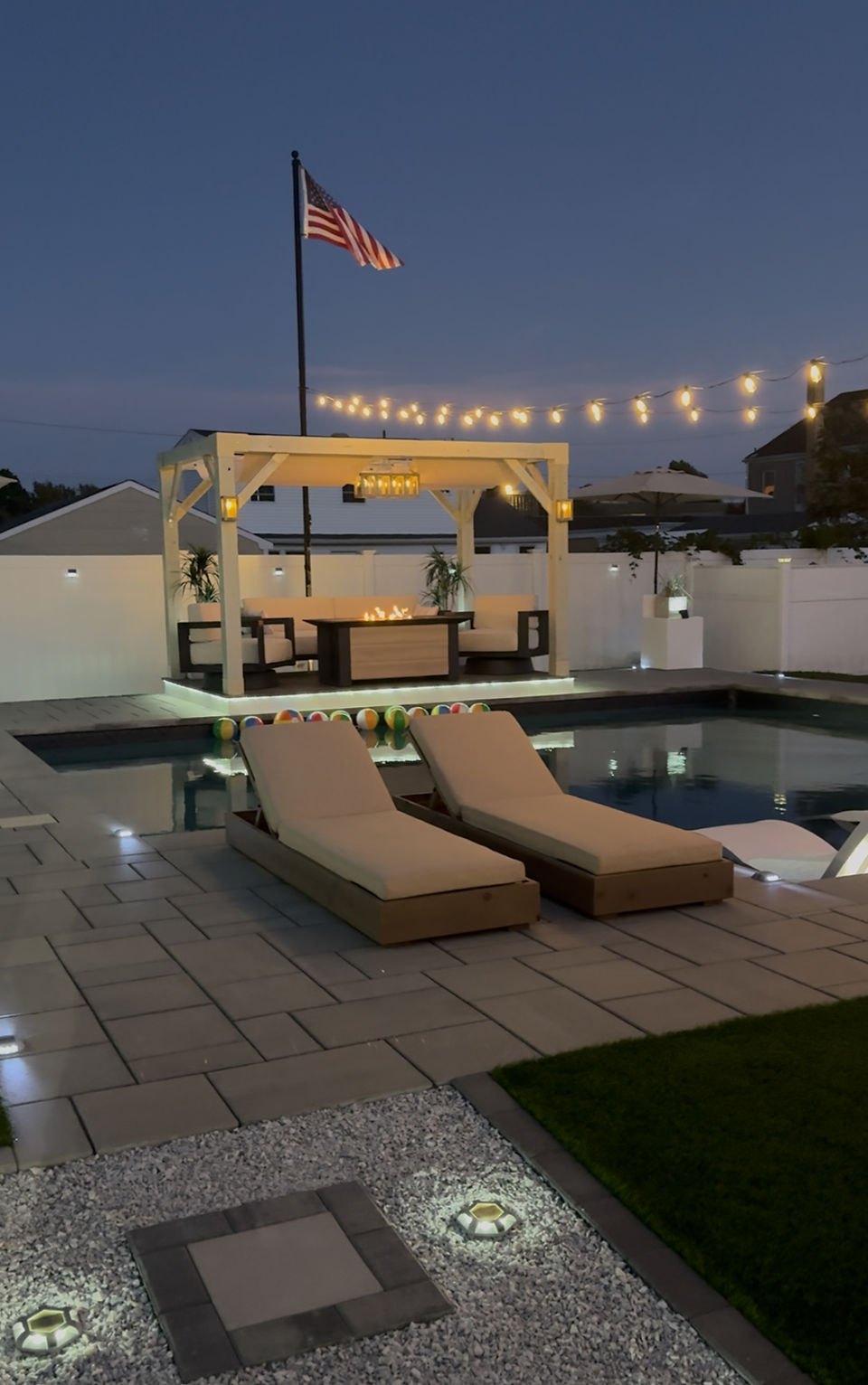 Nighttime view of loungers next to a pool.