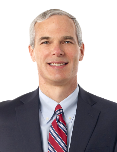 Smiling man in a suit and tie from the Our Team page.