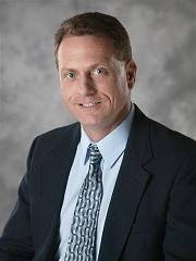 Professional headshot of a man in a suit and tie