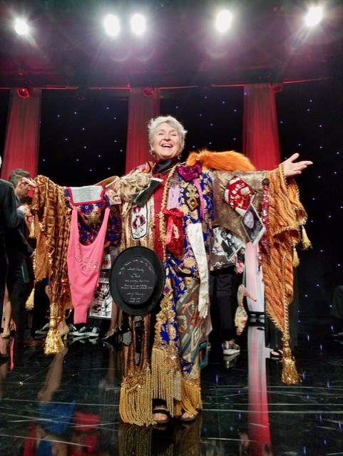 Performer in an ornate, colorful costume on stage.