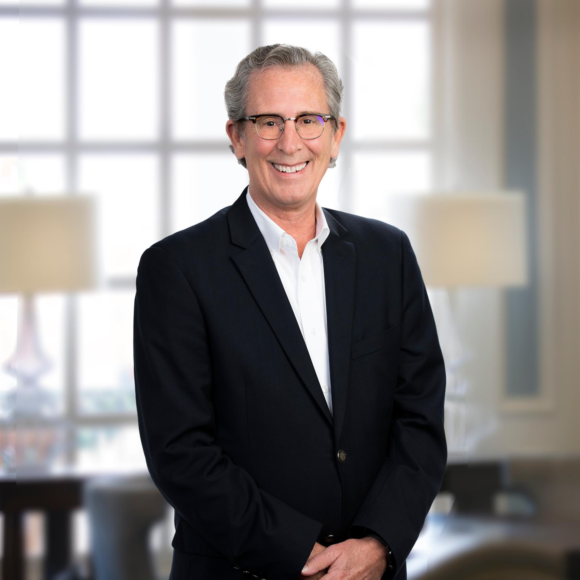 Smiling businessman in a black blazer and glasses