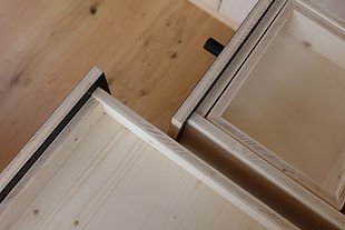 Geöffnete Schubladen aus 3 Schichtplatte mit kleinem schwarzen Knauf.