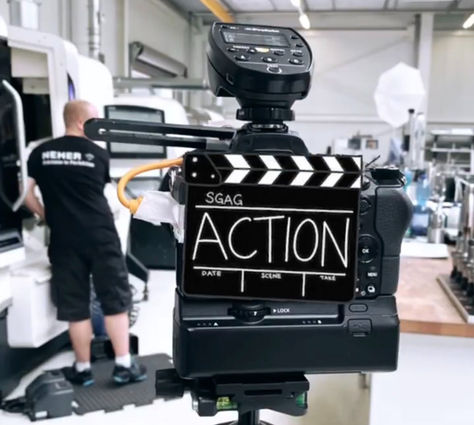 Kamera von hinten, darauf steht "Action", making of eines Shooting