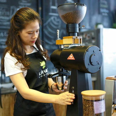 A pretty Asian barista making coffee in a coffee shop. ESL beginner lesson