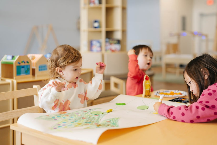 Children coloring while seated at a table, children's play place, indoor play space, play place, sensory play
