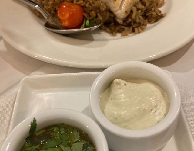 Meagre steak on mujadara rice with two sides