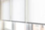Modern white roller blinds elegantly covering windows in a bright, minimalist room during 
