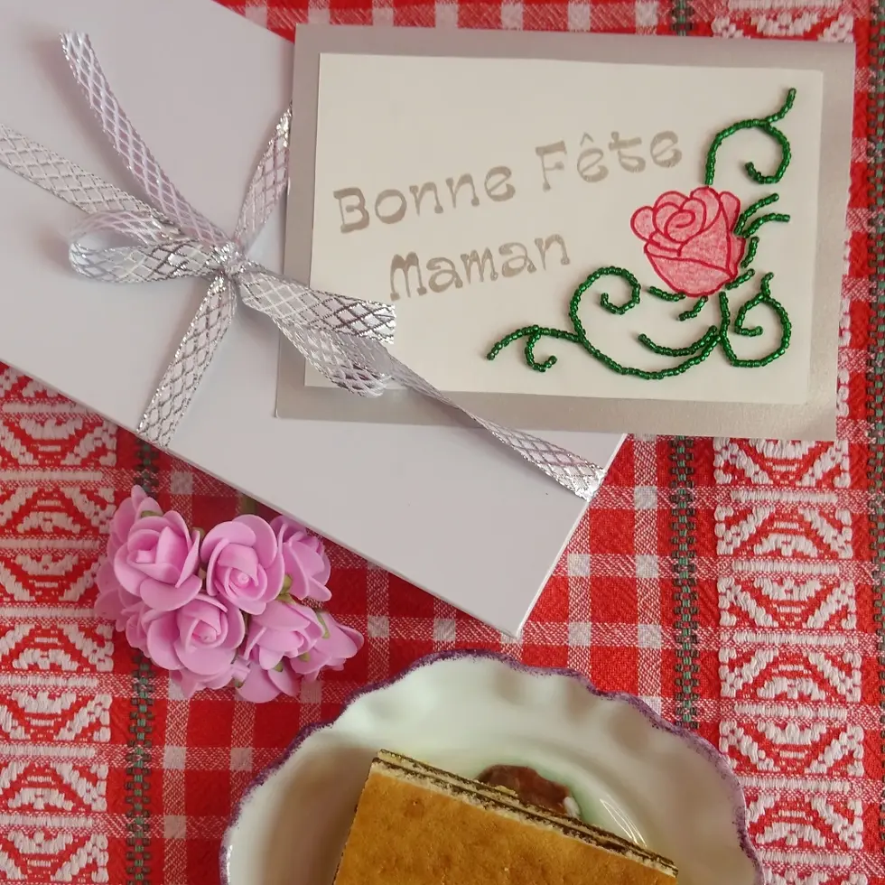 Miniature : Carte bonne fête maman glissée dans un paquet cadeau avec petit bouquet et part de gâteau maison