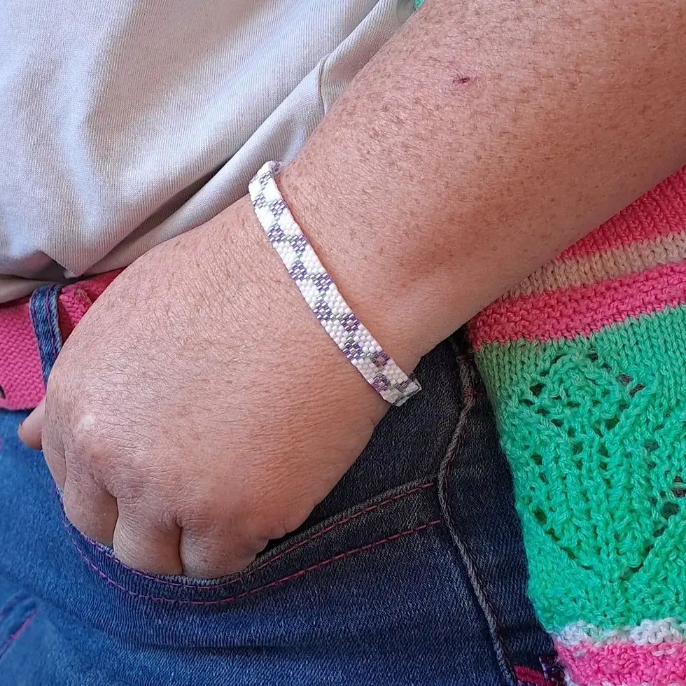 Miniature : Bracelet petites fleurs en perles miyuki tissées mauve porté main dans la poche