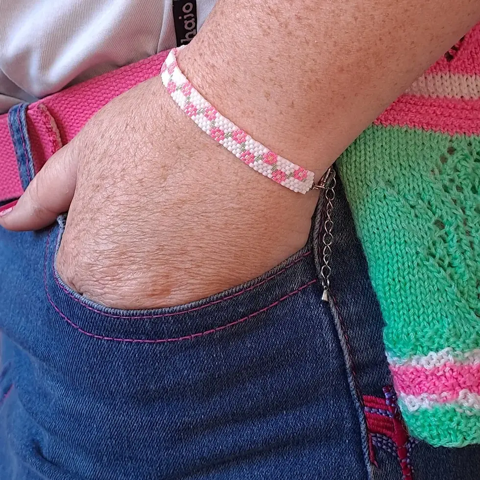 Bracelet petites fleurs en perles miyuki tissées rose porté main dans la poche