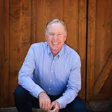 Man sitting in front of door, smiling
