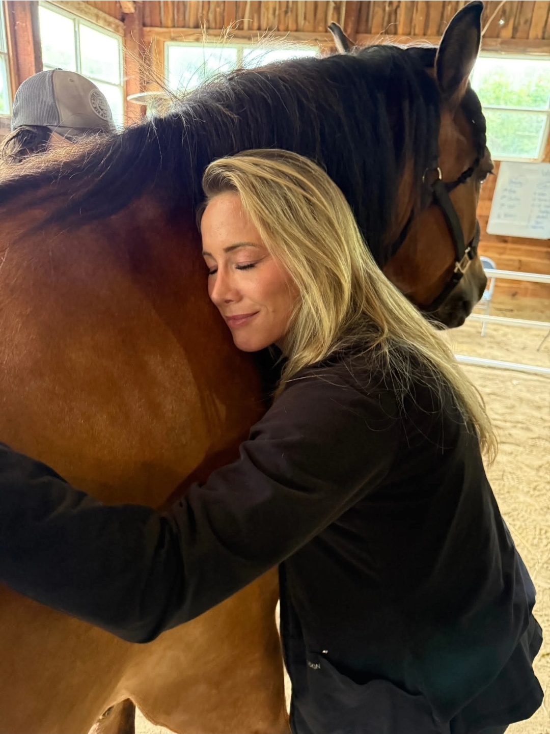 Two women with a white pony in the arena