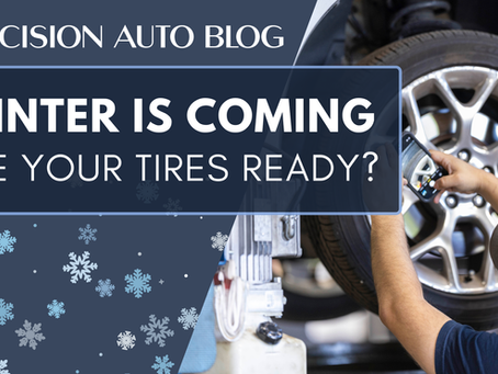 "Blog post cover image for 'Precision Auto Blog' titled 'WINTER IS COMING ARE YOUR TIRES READY?'. The image features a mechanic working on a car tire lifted in a garage, overlaid with a dark blue banner and falling snowflake graphics.