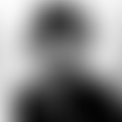 Black and white portrait of a smiling woman in a military uniform and cap, with insignia and buttons visible, on a plain backdrop.