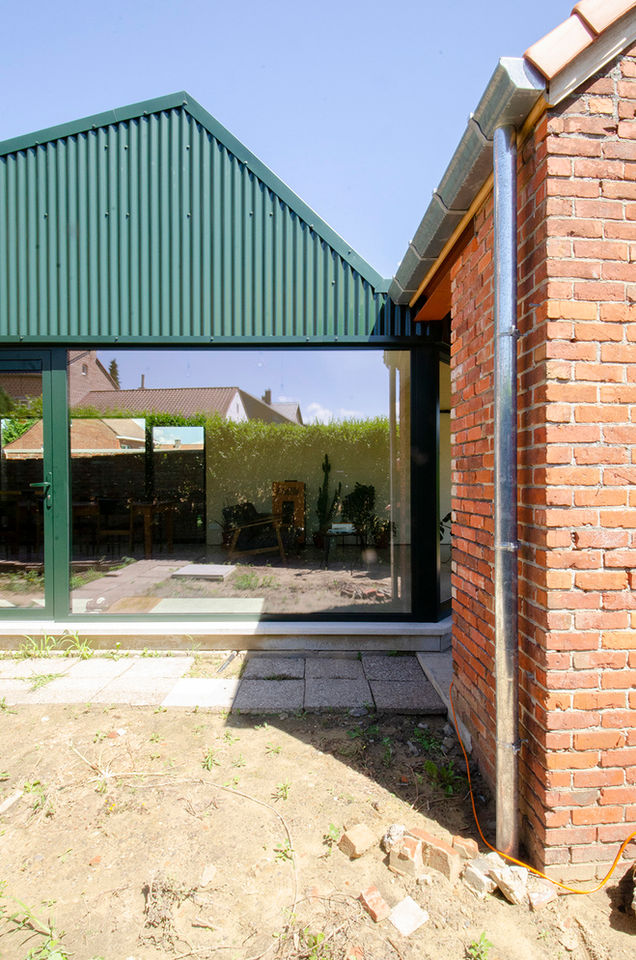 Nieuw volume als schakel tussen woning en tuin met gevel in groene golfplaten