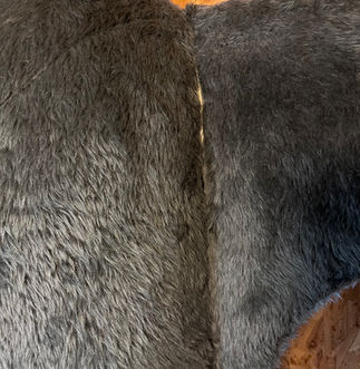 Side view of Sid the Shark’s fin showing visible holes and worn fabric before restoration.