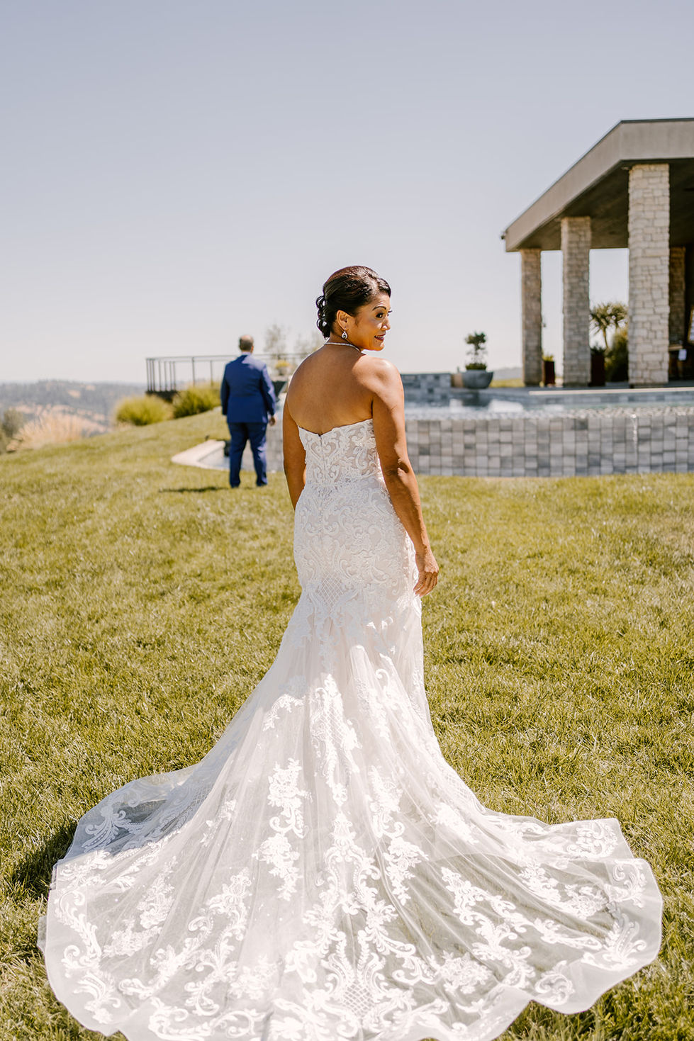 a woman in a wedding dress is standing in the grass