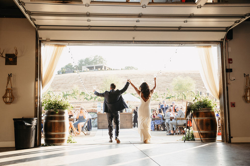 a bride and groom celebrate their wedding with their arms in the air