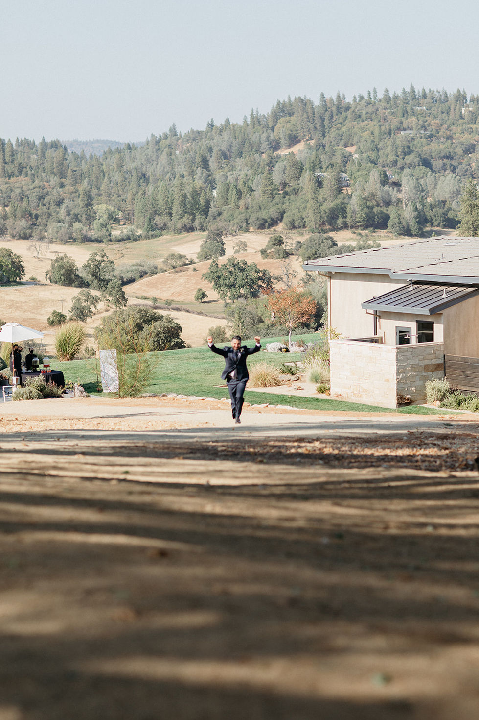 a man in a suit is running down a dirt road