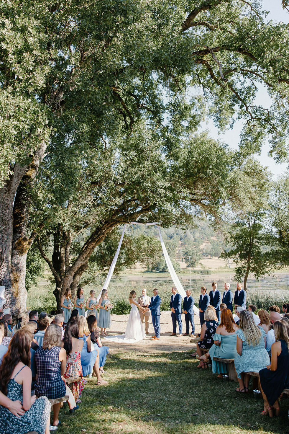 a bride and groom are getting married under a tree