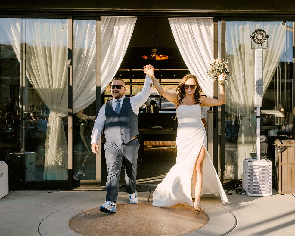 a bride and groom are walking through a doorway holding hands