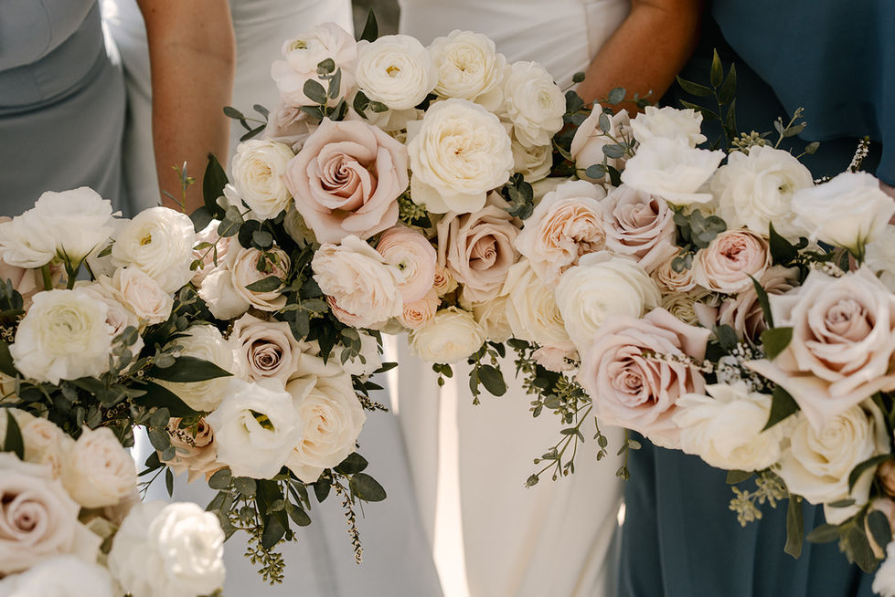 a bride and bridesmaid hold a bouquet of white and pink flowers