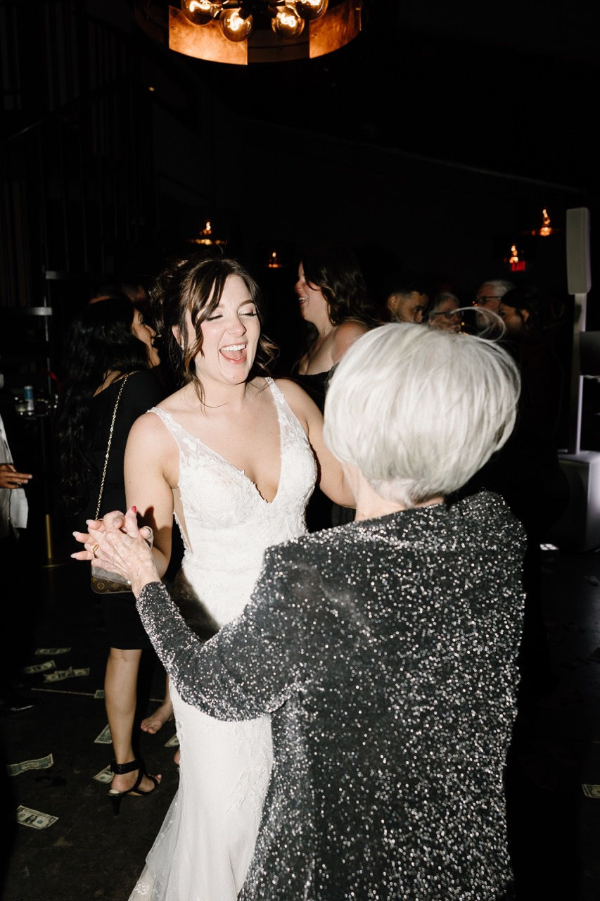 a woman in a black dress is dancing with a woman in a white dress
