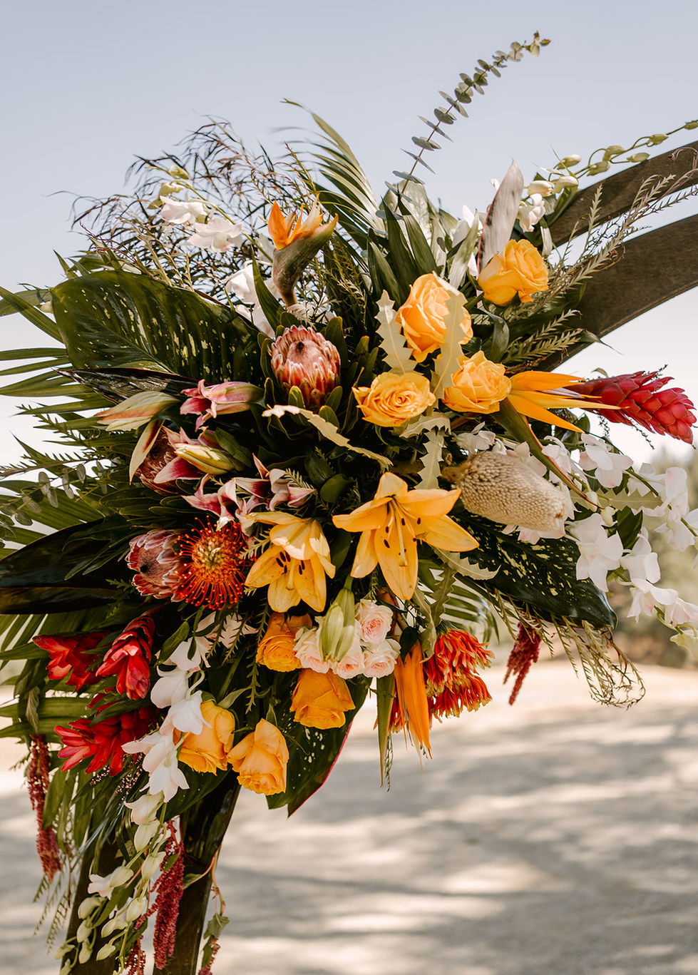 a large bouquet of flowers including yellow roses and red flowers