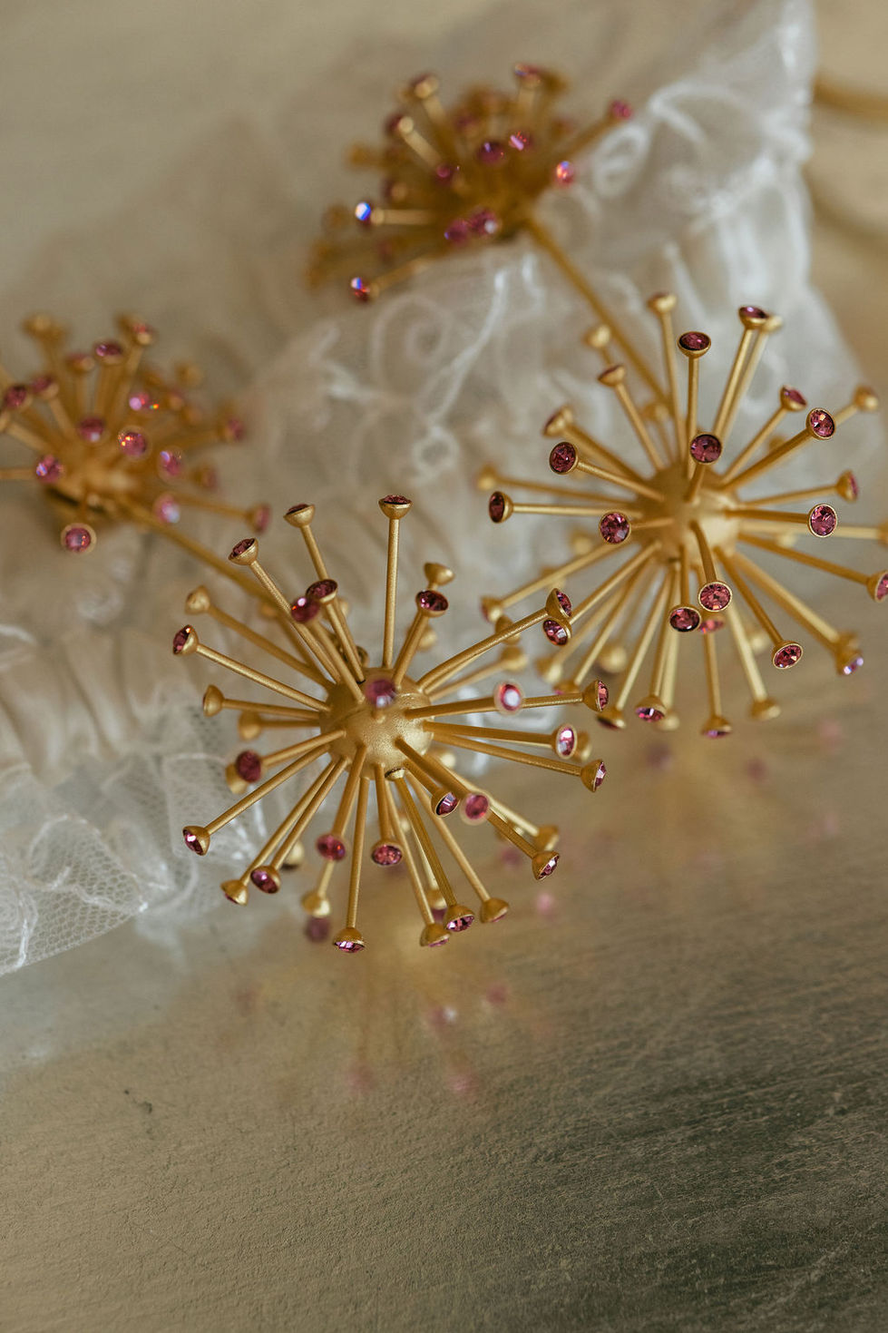 a close up of a gold object with pink rhinestones