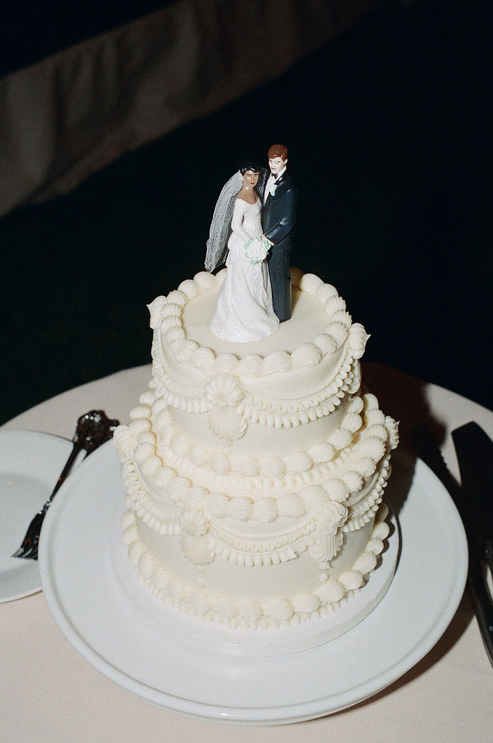 a wedding cake with a bride and groom figurine on top