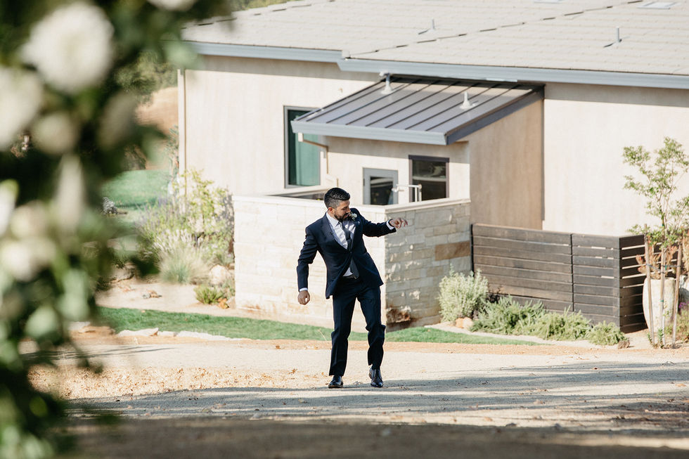a man in a suit is dancing in front of a house