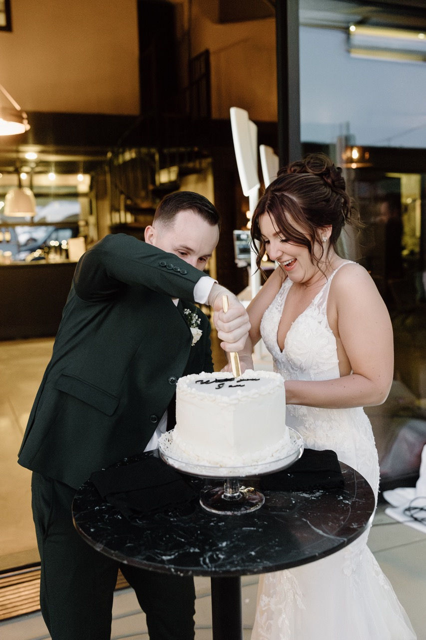 a bride and groom are cutting their wedding cake together