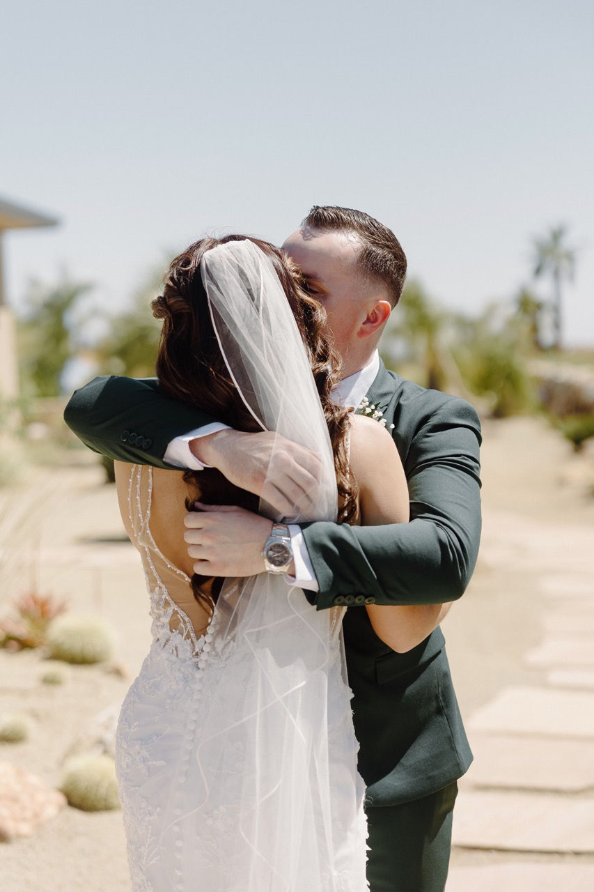 a bride and groom hugging with the bride wearing a veil