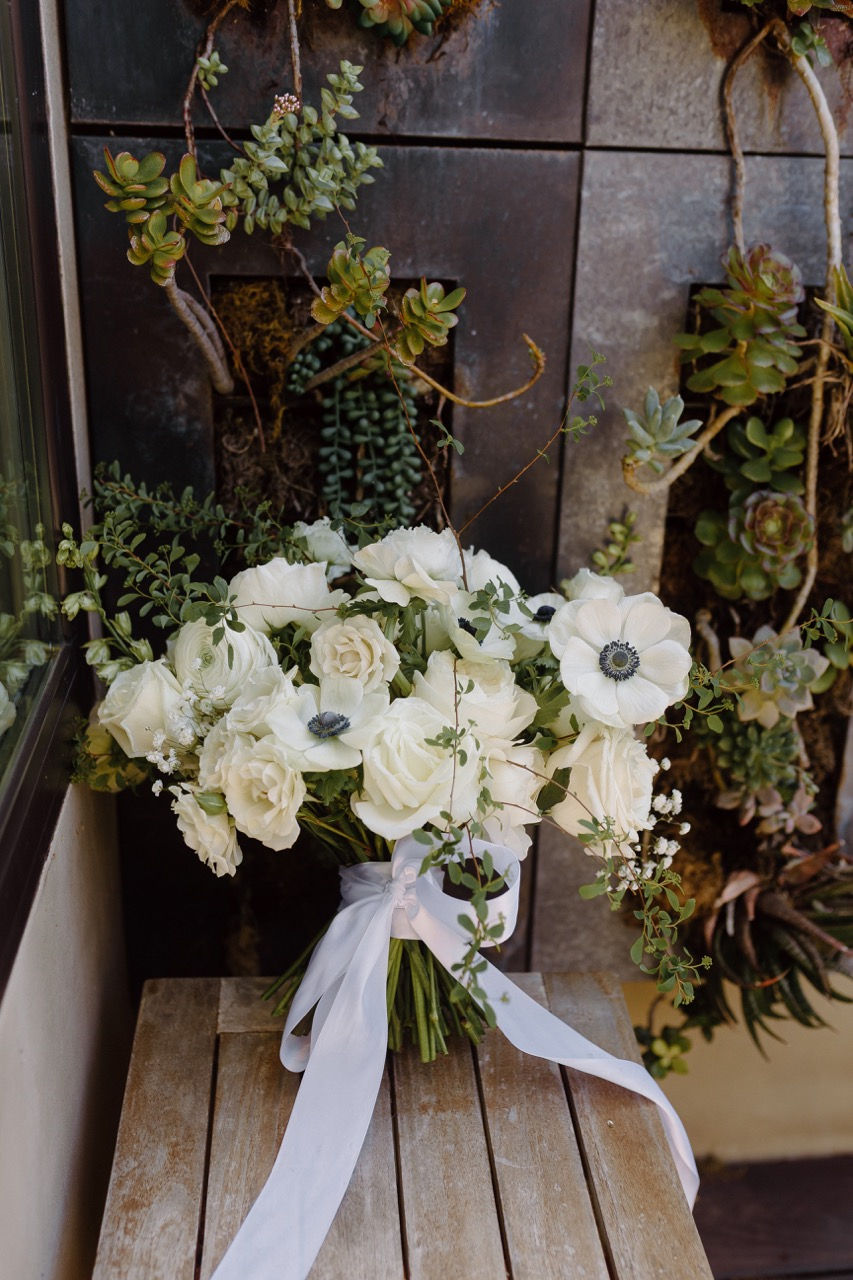 a bouquet of white flowers is tied with a white ribbon