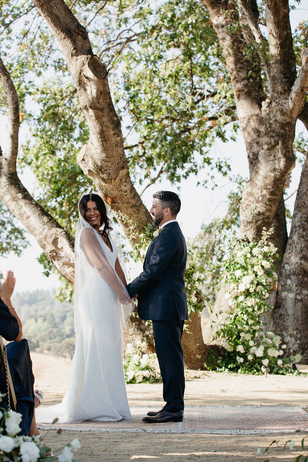 a bride and groom hold hands during their wedding ceremony
